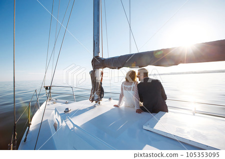 Beautiful wedding couple on yacht at wedding day outdoors in the sea. Together. Wedding day. Beautiful wedding couple on yacht at wedding day outdoors in the sea. Together. Wedding day. 105353095