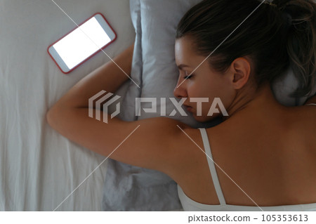 Mobile phone lying near sleeping woman. Mobile phone lying near sleeping woman. 105353613