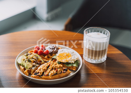 Homemade waffles with different toppings on a white plate with coffee 105354530