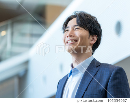 Portrait of a young smiling man standing in the lobby of an office building 105354967