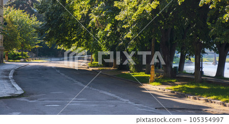 river waterfront at sunrise in shade of trees. longest linden alley in europe. popular travel destination river waterfront at sunrise in shade of trees. longest linden alley in europe. popular travel destination 105354997