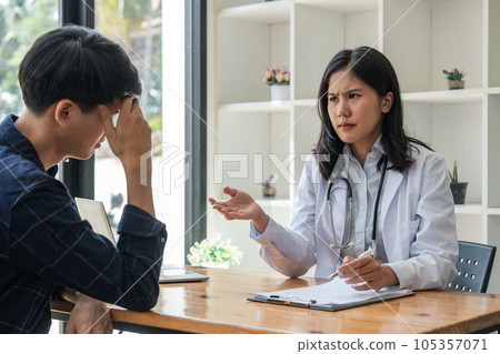 Young asian woman doctor consulting asian worried patient patient on room in hospital, friendly female physician practitioner talking, giving recommendation, discussing checkup or symptoms 105357071