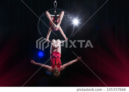 Circus actress acrobat performance. Two girls perform acrobatic elements in the air ring. 105357666
