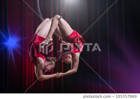 Circus actress acrobat performance. Two girls perform acrobatic elements in the air ring. Circus actress acrobat performance. Two girls perform acrobatic elements in the air ring. 105357669