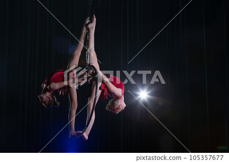 Circus actress acrobat performance. Two girls perform acrobatic elements in the air ring. Circus actress acrobat performance. Two girls perform acrobatic elements in the air ring. 105357677