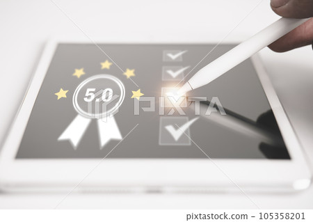 Businessman give the 5 star for best quality score by using tablet, product warranty, ISO standard and quality assurance concept. Businessman give the 5 star for best quality score by using tablet, product warranty, ISO standard and quality assurance concept. 105358201