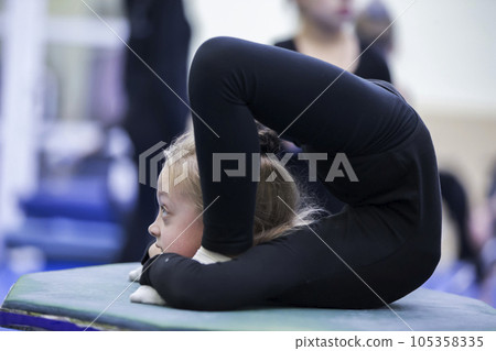 Gymnastic workout. Girl with a flexible body Gymnastic workout. Girl with a flexible body 105358335