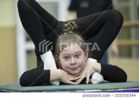 Gymnastic workout. Girl with a flexible body Gymnastic workout. Girl with a flexible body 105358344