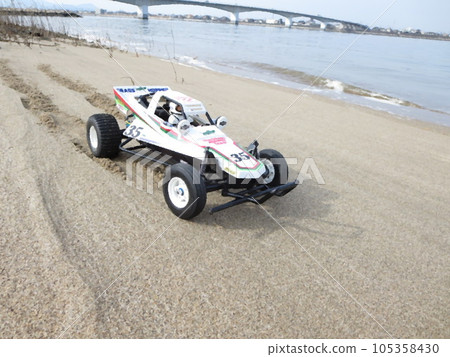 Buggy-type radio-controlled car running on the beach by the sea 105358430