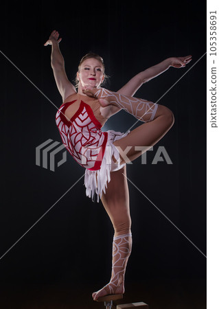 Circus actress performs the number in a beautiful smoke. Manual equilibrium on canes. Flexible girl body.Performance of an air gymnast in a circus Circus actress performs the number in a beautiful smoke. Manual equilibrium on canes. Flexible girl body.Performance of an air gymnast in a circus 105358691