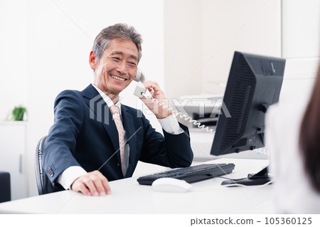 中層管理人員微笑著打電話 105360125