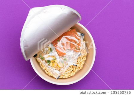 Opened Package with Uncooked Instant Noodles on Violet Background Opened Package with Uncooked Instant Noodles on Violet Background 105360786