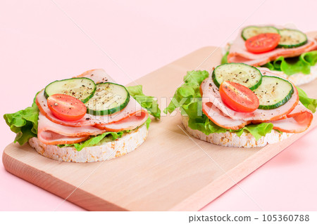 Rice Cakes with Ham, Tomato, Fresh Cucumber and Green Salad 105360788