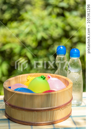 木桶裡的水氣球和一瓶冷的彈珠汽水/暑假形象，昭和復古，日本夏天在水中玩耍 105361296