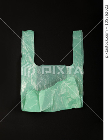 Green Plastic Bags on Black Background, Crumpled Plastic Bag after Shopping, Cellophane Packaging Waste 105362022