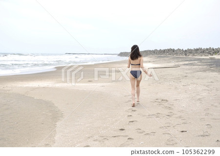 Back view of a young woman wearing a polka dot bikini on the beach Back view of a young woman wearing a polka dot bikini on the beach 105362299