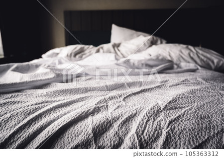 crumpled sheets of a hotel bed in the morning 105363312