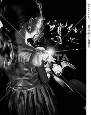 Caucasian girl in dress during a candle light church service. Caucasian girl in dress during a candle light church service. 105363331