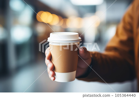 Man's hand holding takeaway paper coffee cup mock up 105364440