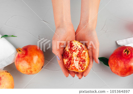Ripe pomegranates on a light gray kitchen table 105364897