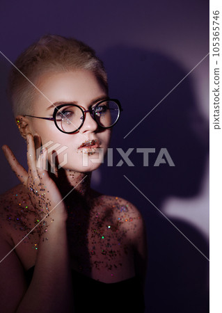 Woman with sequin makeup on her face and neck 105365746