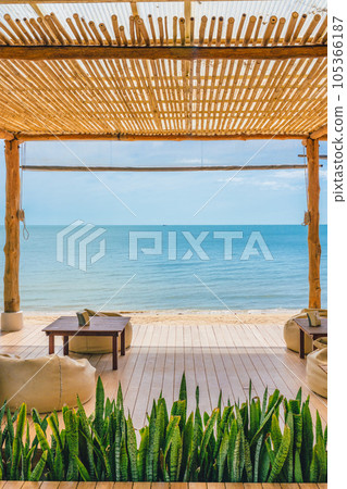 Wooden terrace with table, seat and roof on the beach in tropical sea 105366187