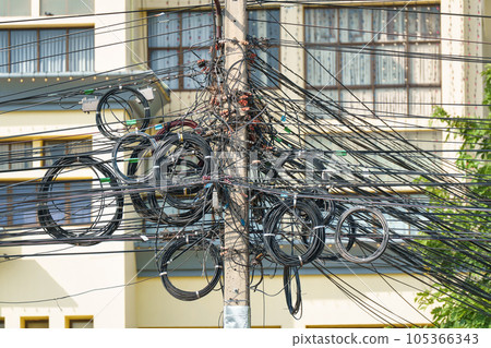 Power wire and communication, telephone, internet cable tangled up on the electric utility pole Power wire and communication, telephone, internet cable tangled up on the electric utility pole 105366343