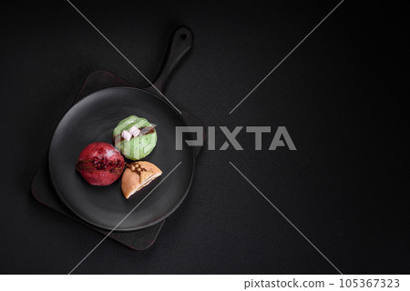 Delicious sweet colorful mochi desserts or ice cream with rice dough and toppings Delicious sweet colorful mochi desserts or ice cream with rice dough and toppings 105367323