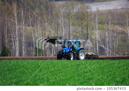 拖拉機在春田裡耕田 105367433