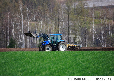 拖拉機在春田裡耕田 105367435