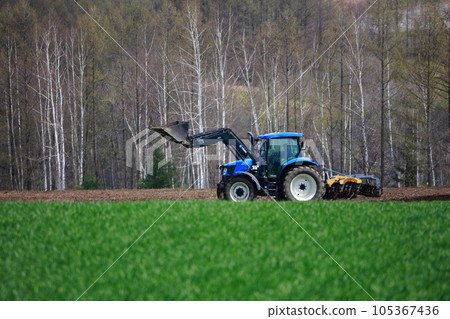 拖拉機在春田裡耕田 105367436