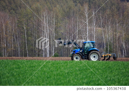 拖拉機在春田裡耕田 105367438