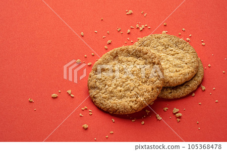Two oatmeal cookies on red background, top view with copy space Two oatmeal cookies on red background, top view with copy space 105368478