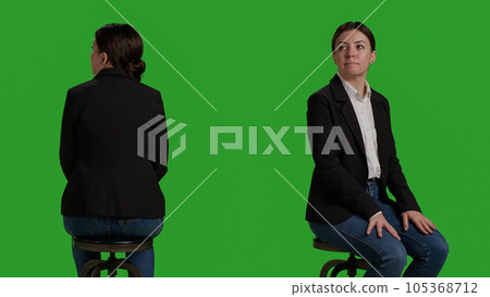 Close up of company worker waiting on chair before attending business meeting, sitting in studio with greenscreen background. Woman dressed in office suit working as employee or manager. Close up of company worker waiting on chair before attending business meeting, sitting in studio with greenscreen background. Woman dressed in office suit working as employee or manager. 105368712