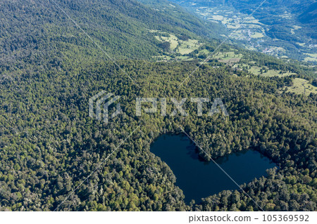 Heart lagoon, Laguna Corazon, Chile. Drone top down view go lagoon with the shape of a heart surrounded by forest, near Liquine, Region Los Lagos Chile Heart lagoon, Laguna Corazon, Chile. Drone top down view go lagoon with the shape of a heart surrounded by forest, near Liquine, Region Los Lagos Chile 105369592