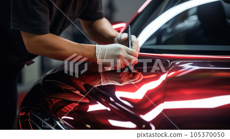 Car wrapping specialist putting vinyl foil or film on car. Selective focus. 105370050