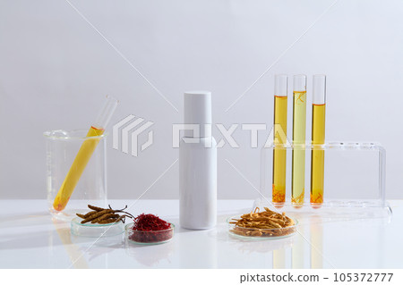 Mockup scene for advertising and branding cosmetic product extracted cordyceps and saffron. An empty bottle displayed on white background with saffron, cordyceps and glassware filled with liquid Mockup scene for advertising and branding cosmetic product extracted cordyceps and saffron. An empty bottle displayed on white background with saffron, cordyceps and glassware filled with liquid 105372777