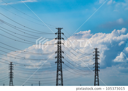 Transmission towers and cumulonimbus clouds in the blue sky of a summer afternoon b-1 105373015