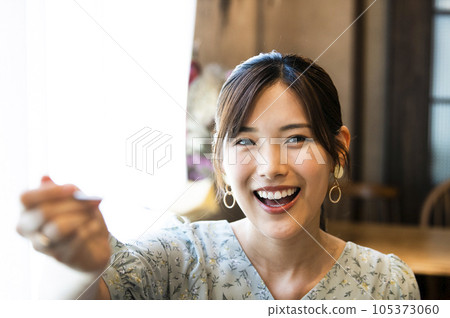 Young woman feeding her boyfriend cheesecake in a cafe 105373060