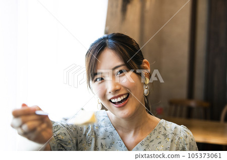 Young woman feeding her boyfriend cheesecake in a cafe 105373061