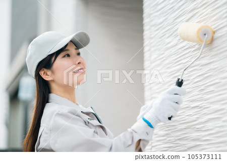 Young woman of renovation contractor to paint the exterior wall Young woman of renovation contractor to paint the exterior wall 105373111