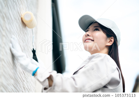 Young woman of renovation contractor to paint the exterior wall 105373113
