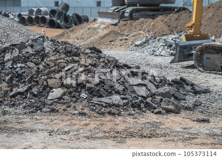 Heavy machinery processing asphalt and waste soil at a civil engineering site 105373114