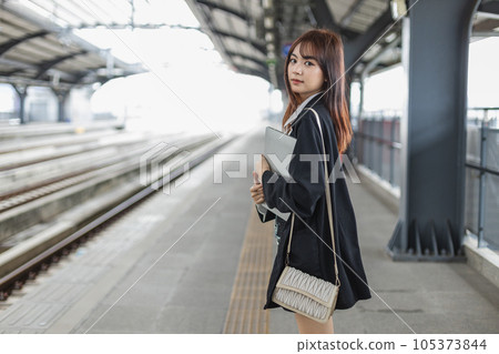 Attractive young woman in black suit holding laptop smiling looking a camera. 105373844
