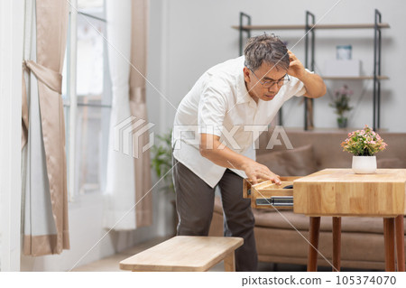 Asian older man finding something that he forgot it in drawers.. 105374070