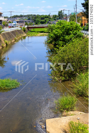 Scenery of a river flowing through a suburban residential area 105374092