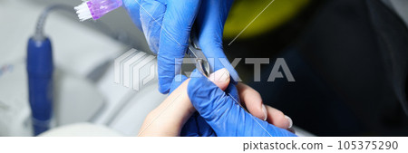 Beauty salon specialist makes manicure for female client. 105375290
