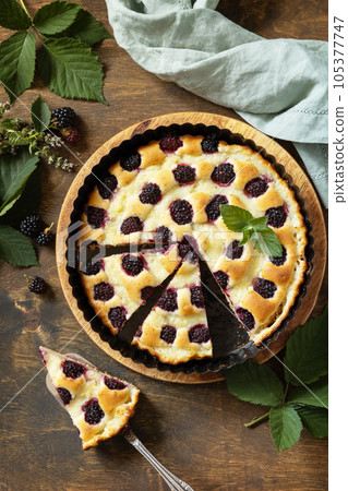 Sweet pie with blackberry and custard on wooden table. Homemade blackberry pie. Vegan gluten-free pastry, vegan desserts. View from above. Sweet pie with blackberry and custard on wooden table. Homemade blackberry pie. Vegan gluten-free pastry, vegan desserts. View from above. 105377747