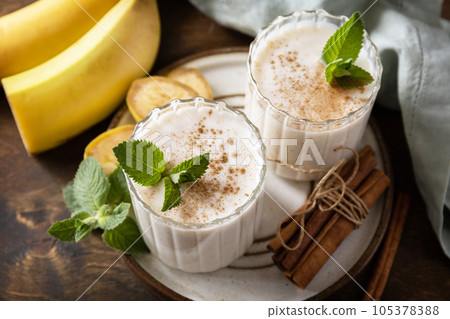 Detox menu. Banana smoothie with cinnamon in drinking glass on a wooden background. 105378388