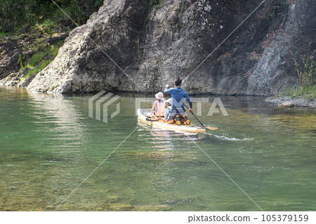 父母和孩子在清澈的溪流中汲取汁液 父母和孩子在清澈的溪流中汲取汁液 105379159